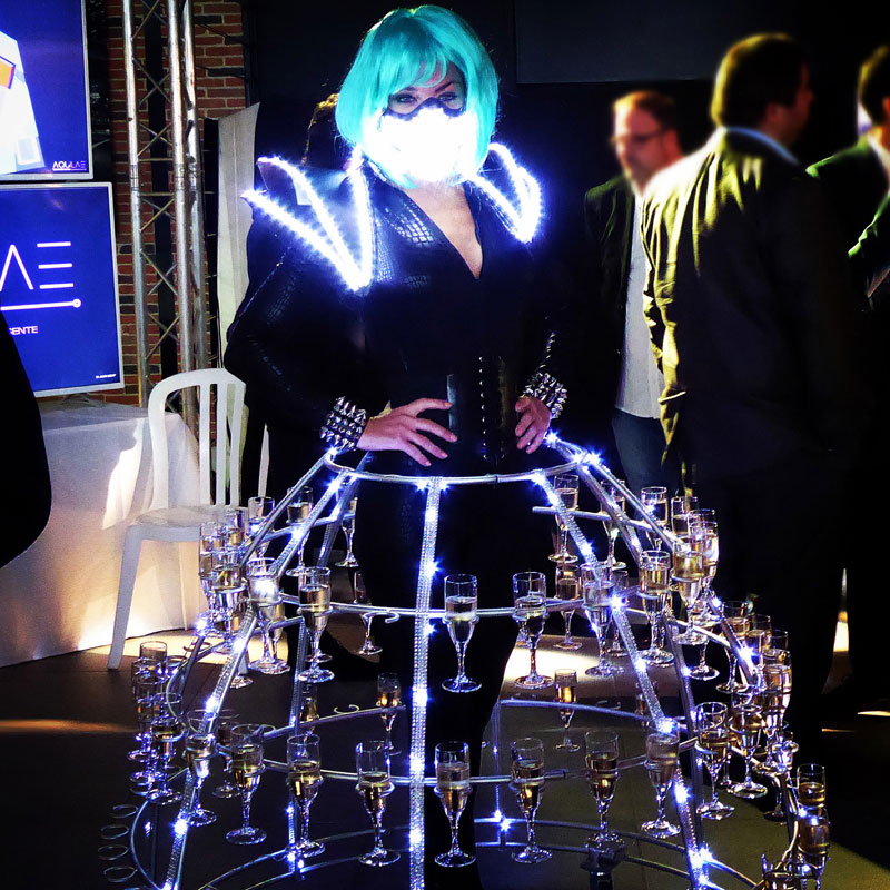 Hôtesse en robe à champagne futuriste accueillant les invités