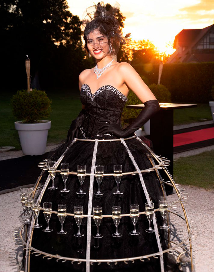 Hôtesse en robe à champagne noire pailletée lors d’un événement